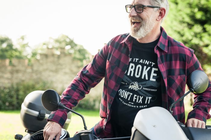 Happy senior man getting onto motorbike in countryside for e-commerce campaign - photographer Colin Hawkins, Bath