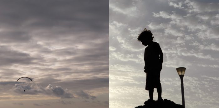 silhouettes in the sky of young boy & paraglider by commercial photographer Colin Hawkins