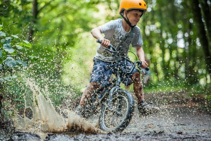 Child cycling through puddle at Tamar Trails by Colin Hawkins