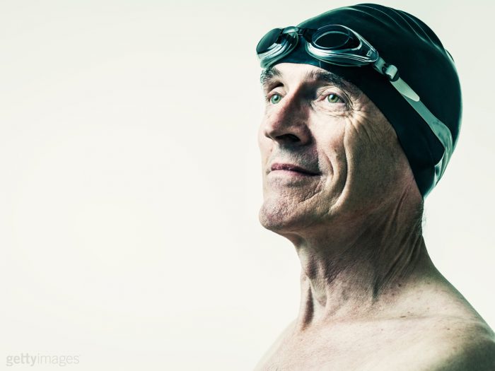 Portrait photography of senior male swimmer wearing swimming hat & goggles by Colin Hawkins