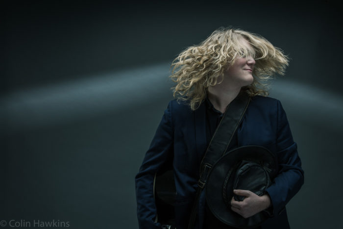 Man shaking head with hair frozen in the by the flash light. Music promotional photography for J Harriman by Colin Hawkins