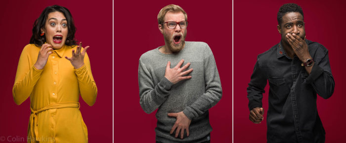 Advertising portrait photography of people with expressions whilst watching a movie against red background by Colin Hawkins. Left image is a woman in a yellow dress looking shocked or surprised. Central image is bearded man looking shocked or disgusted. Right image is a black male looking disgusted or about to be sick.