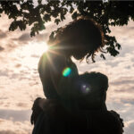 Silhouette of young couple hugging outside at sunset by photographer Colin Hawkins