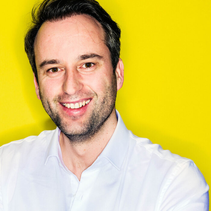 Business portrait photography of man in front of yellow background